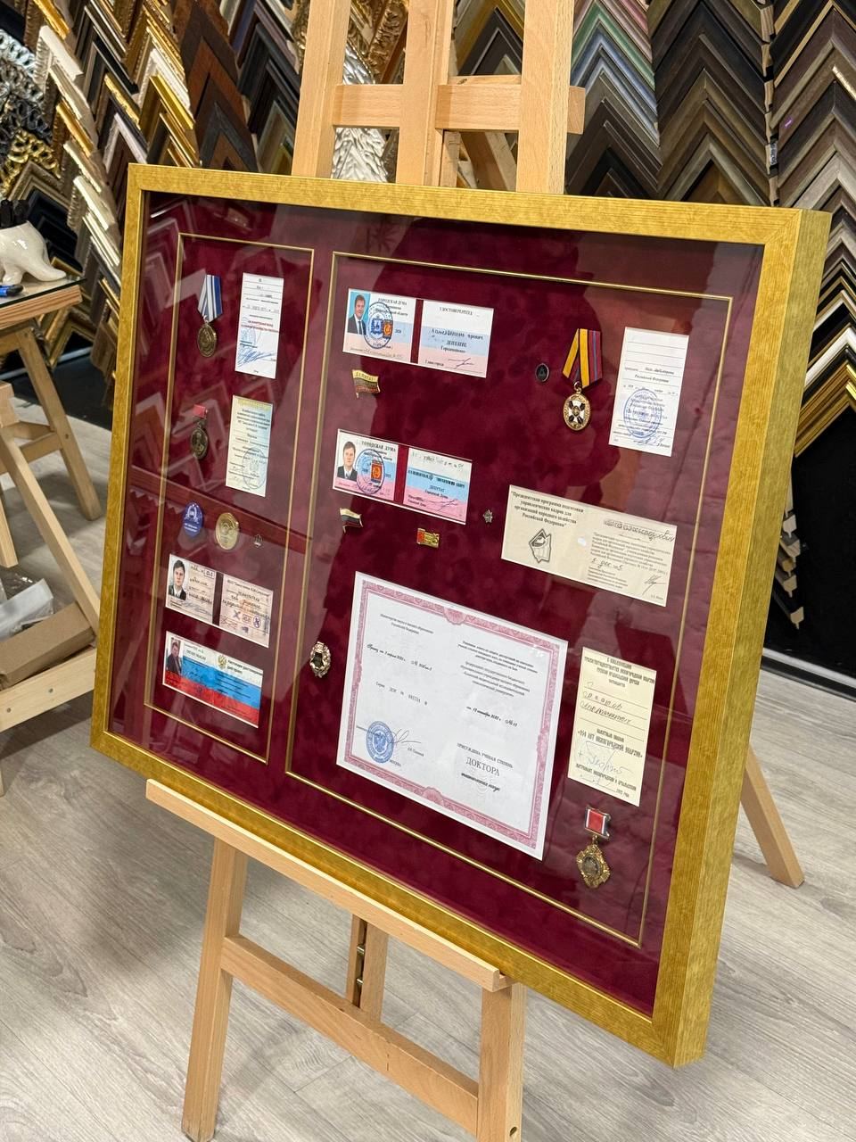 Оформление панно из удостоверений и наград в багет