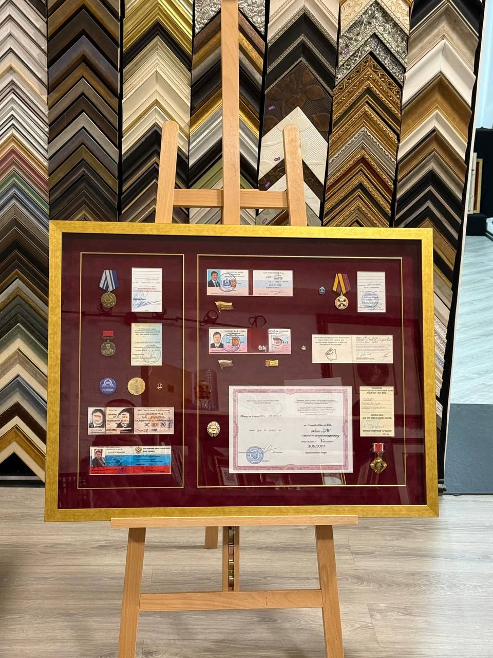 Оформление панно из удостоверений и наград в багет