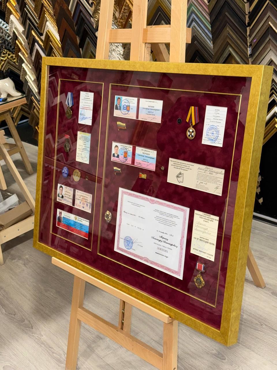 Оформление панно из удостоверений и наград в багет